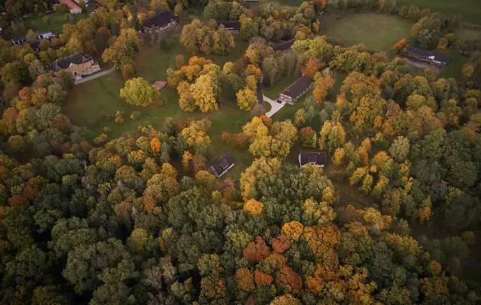 Luftbildansicht des Schloßparks am Tollensesee mit Herrenhaus und Fachwerkhäusern